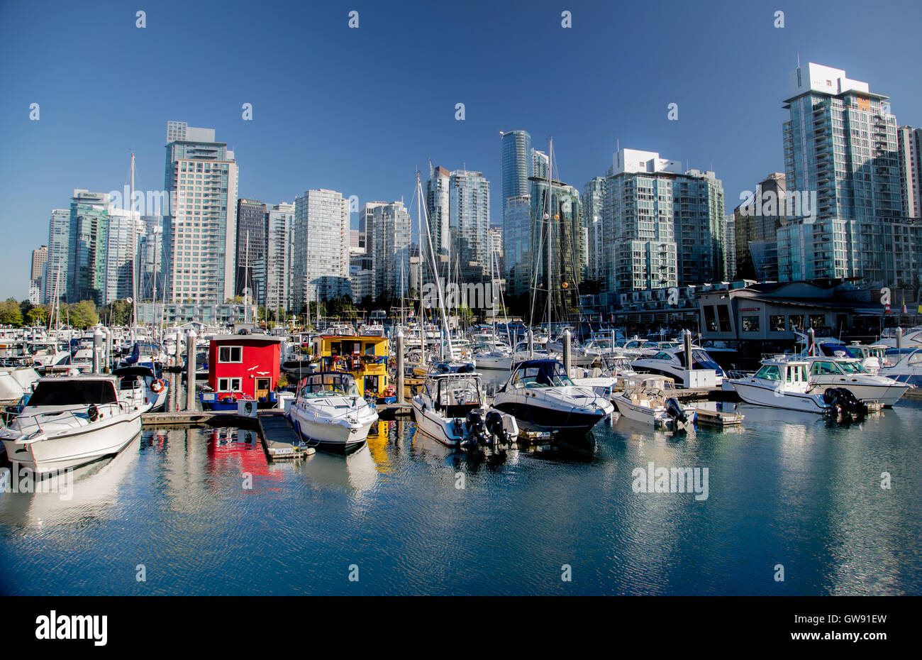 Lo skyline di Vancouver vista dal porto di carbone. Canada giallo casa galleggiante denominato Karma nel centro. Foto Stock