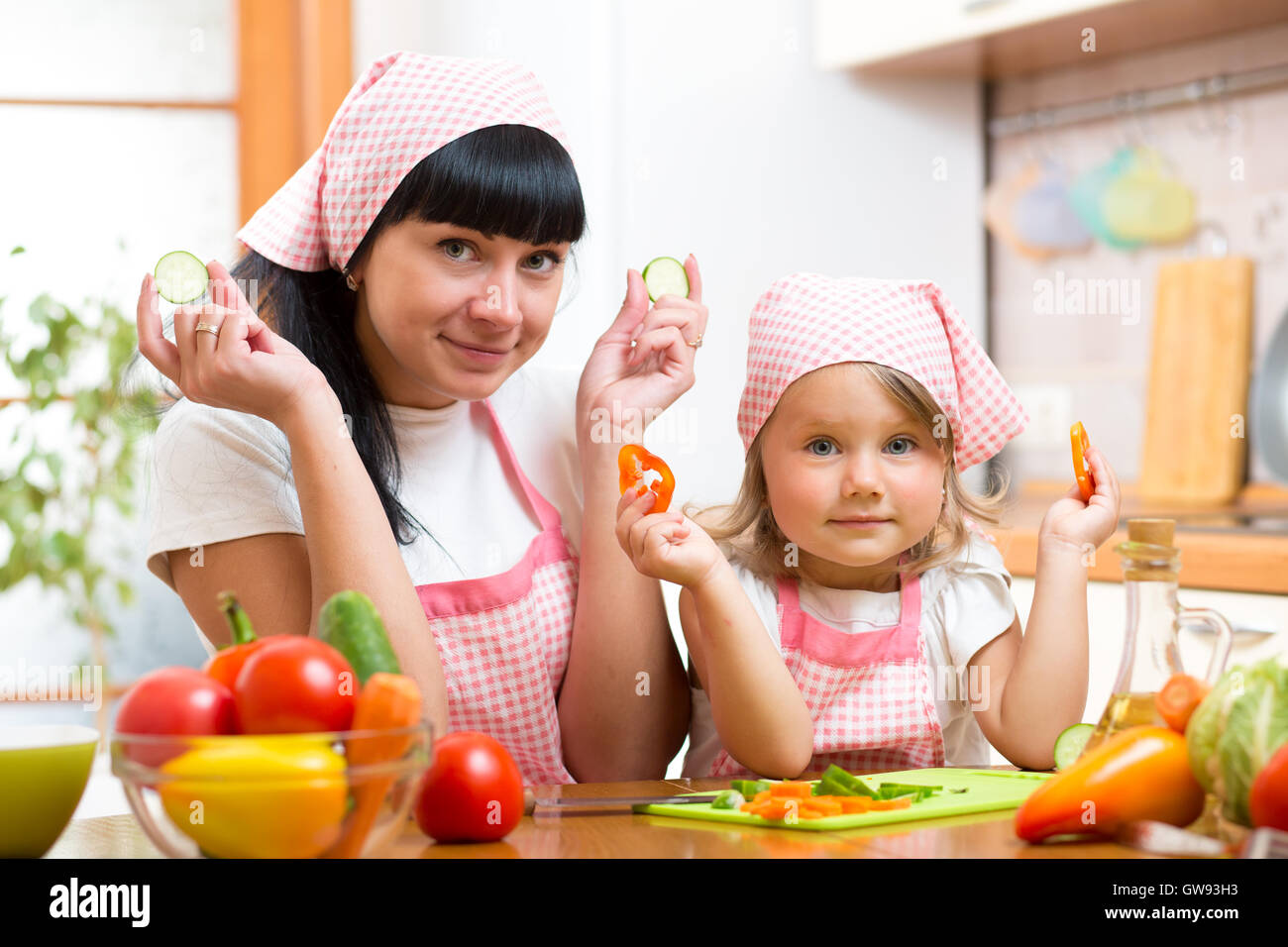 Donna e bambino bambina preparare verdura in cucina Foto Stock