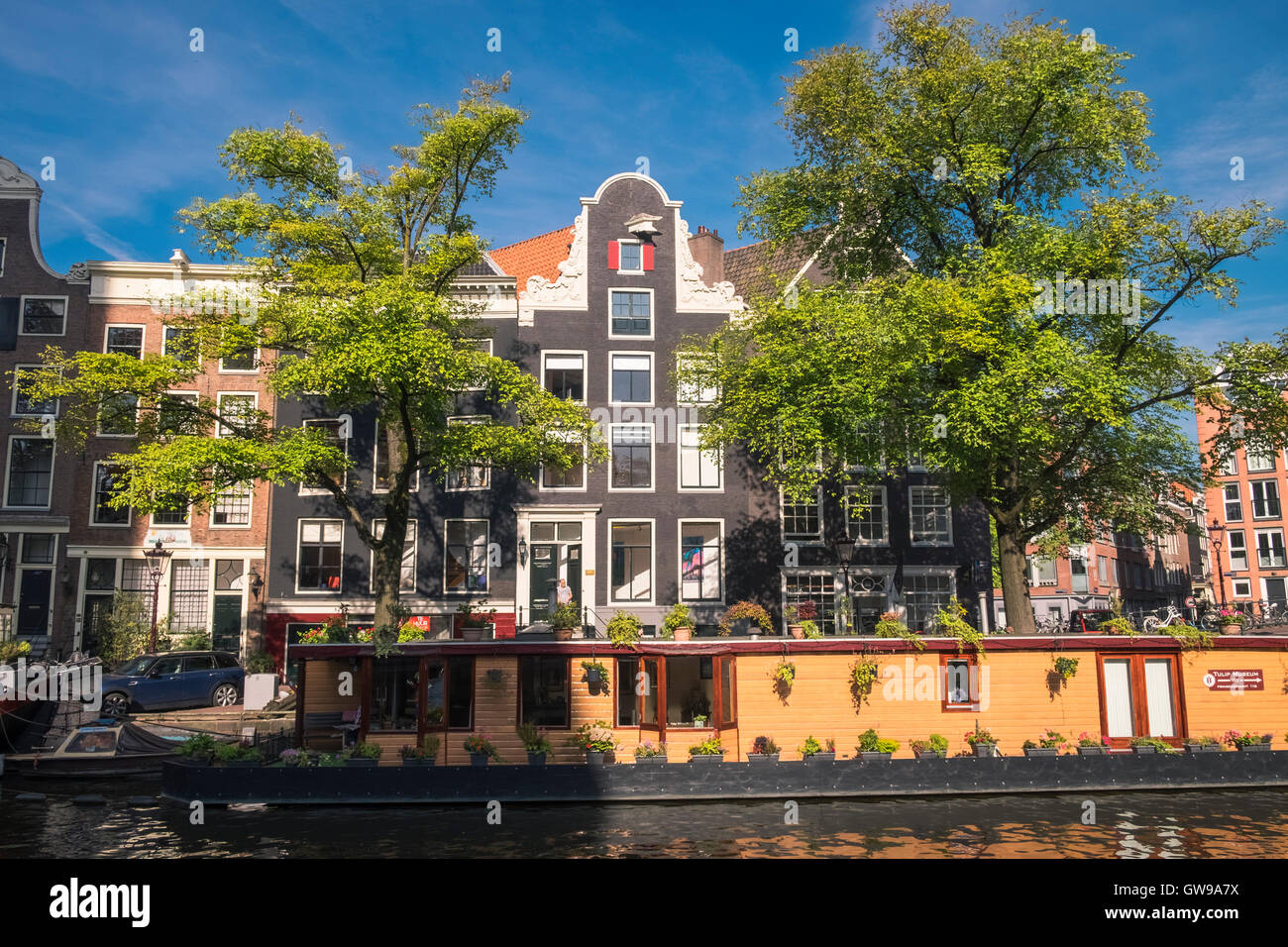 Una grande e colorata casa galleggiante ormeggiato sul canale Prinsengracht, quartiere Jordaan, Amsterdam, Paesi Bassi. Foto Stock
