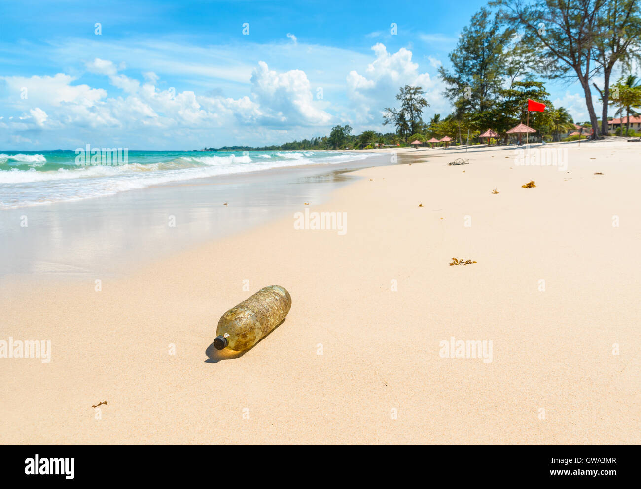 Vecchia bottiglia di plastica su una bella spiaggia tropicale in Indonesia. Concetto di inquinamento. Foto Stock