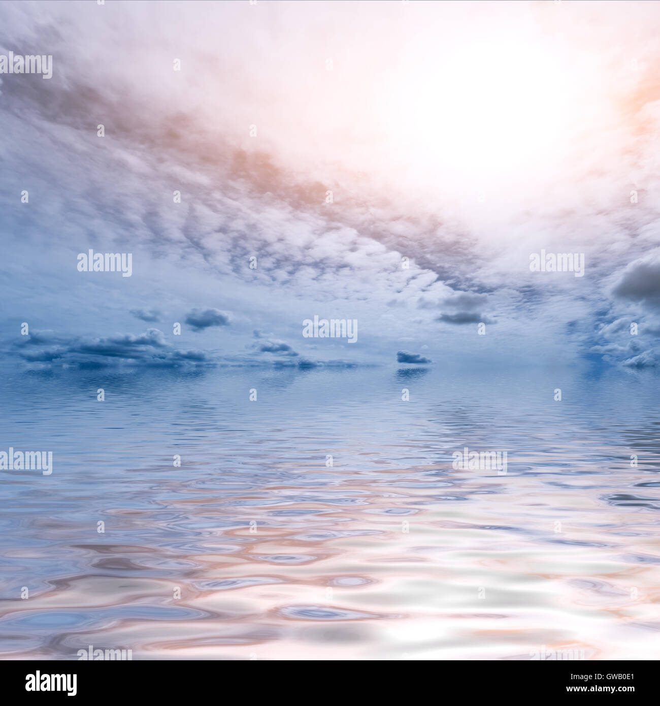Luce blu e rosa cielo astratto e Sfondo oceano: sole splendente e cumulus pattern di nuvole che riflette in acqua fluttuante Foto Stock