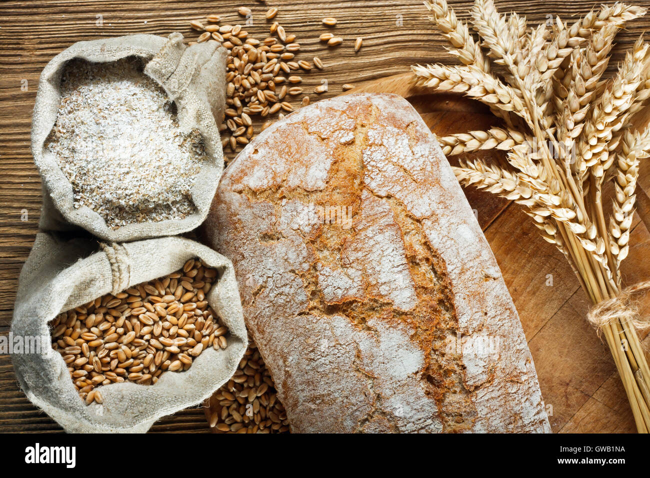 In casa della pagnotta di pane con gli ingredienti sul tavolo di legno Foto Stock