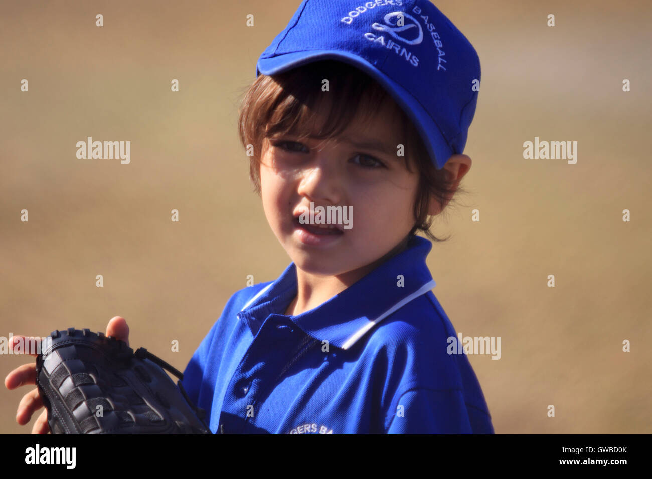 Un giovane ragazzo nella sua uniforme da baseball durante un gioco teeball in Cairns, Australia Foto Stock