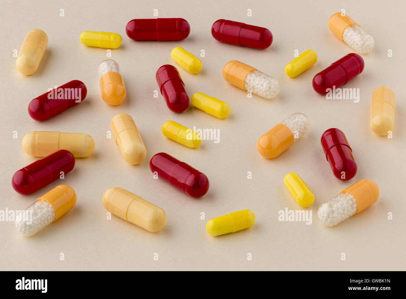 Varie Il giallo e il rosso capsule mediche su sfondo chiaro Foto Stock