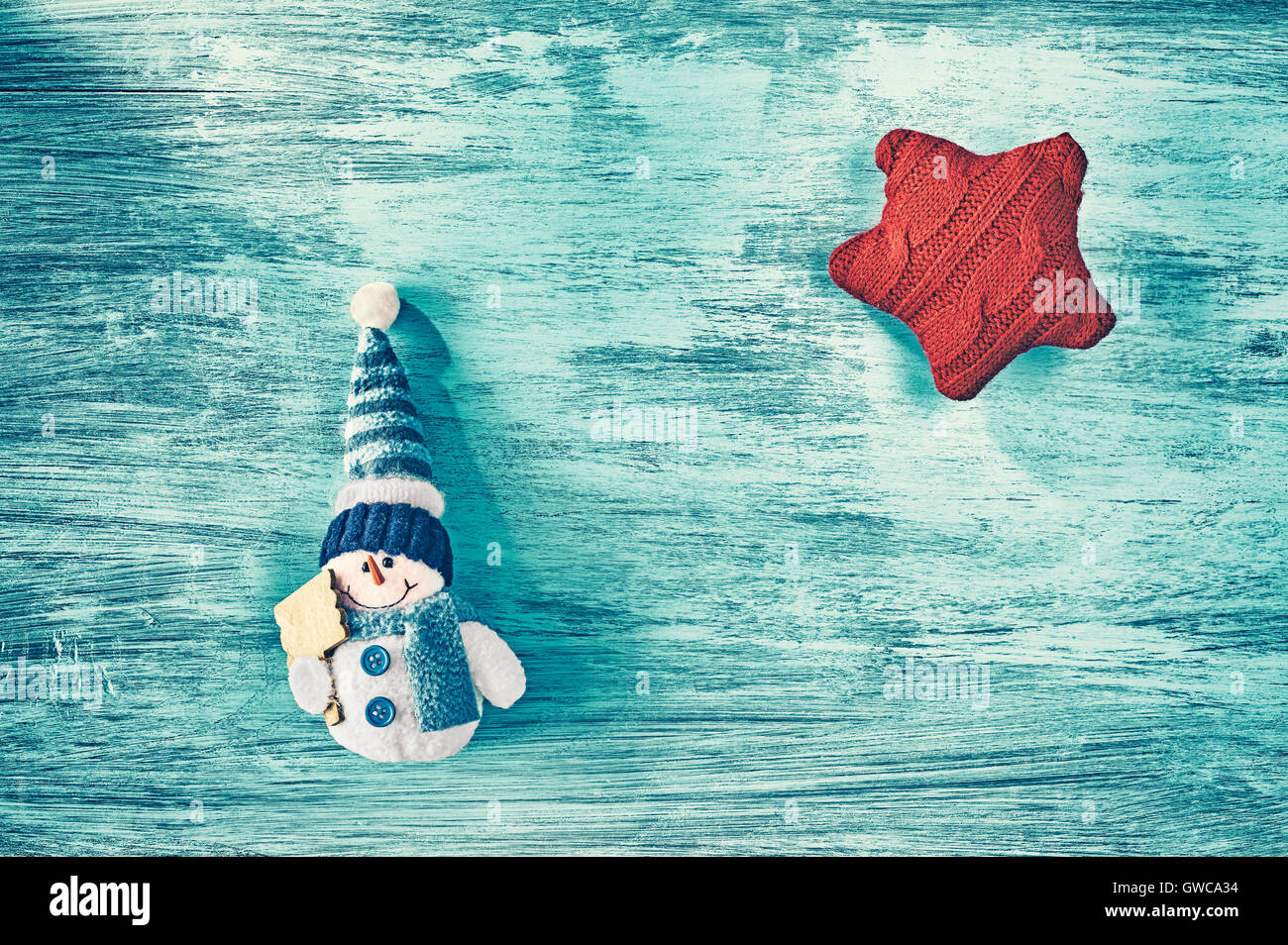 Vintage stilizzata pupazzo giocattolo e stella rossa su un blu tavola in legno rustico, vista dall'alto, Natale sfondo con copia spazio. Foto Stock