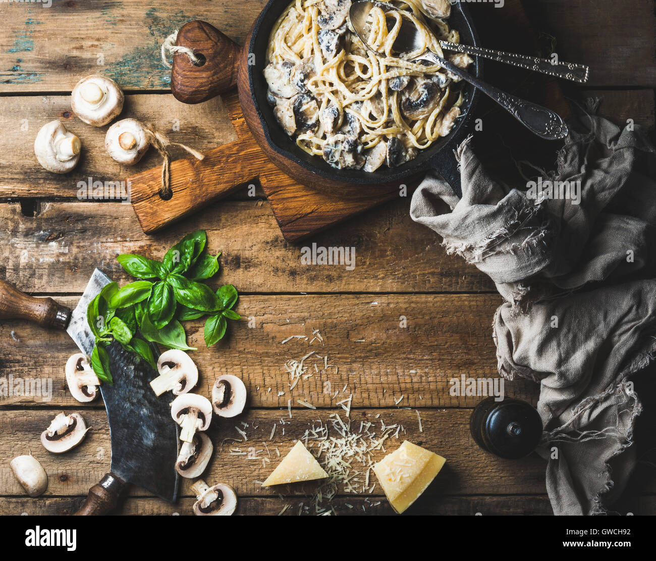 Stile Italiano cena con copia spazio. Crema di funghi spaghetti di pasta in ghisa padella con parmigiano e basilico fresco e pep Foto Stock