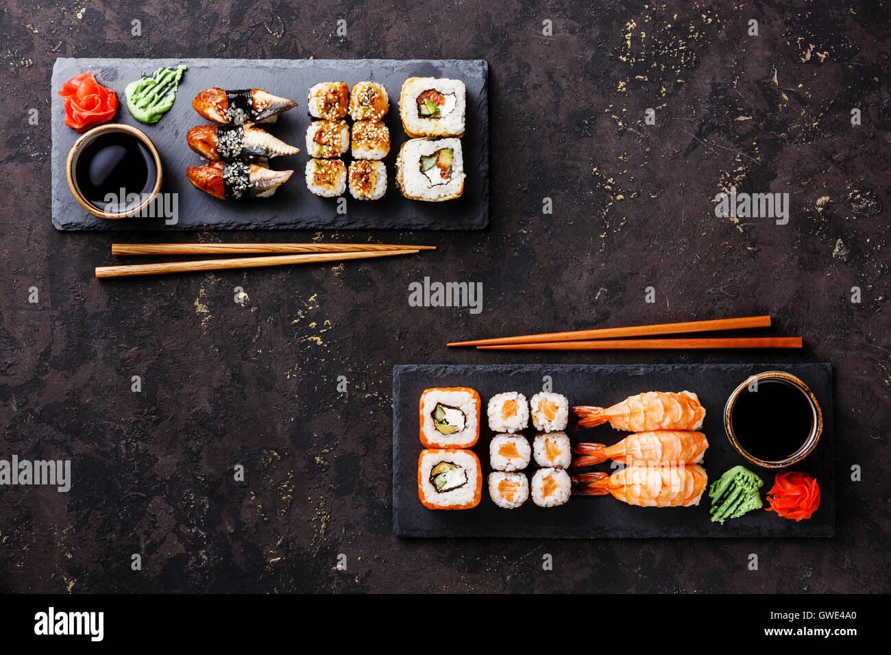 Sushi rotoli maki e nigiri impostare servito per due su nero ardesia pietra su sfondo scuro Foto Stock