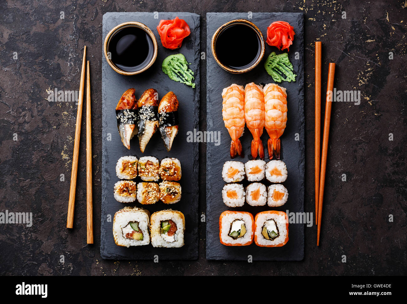 Sushi rotoli maki e nigiri impostare servito per due su nero ardesia pietra su sfondo scuro Foto Stock