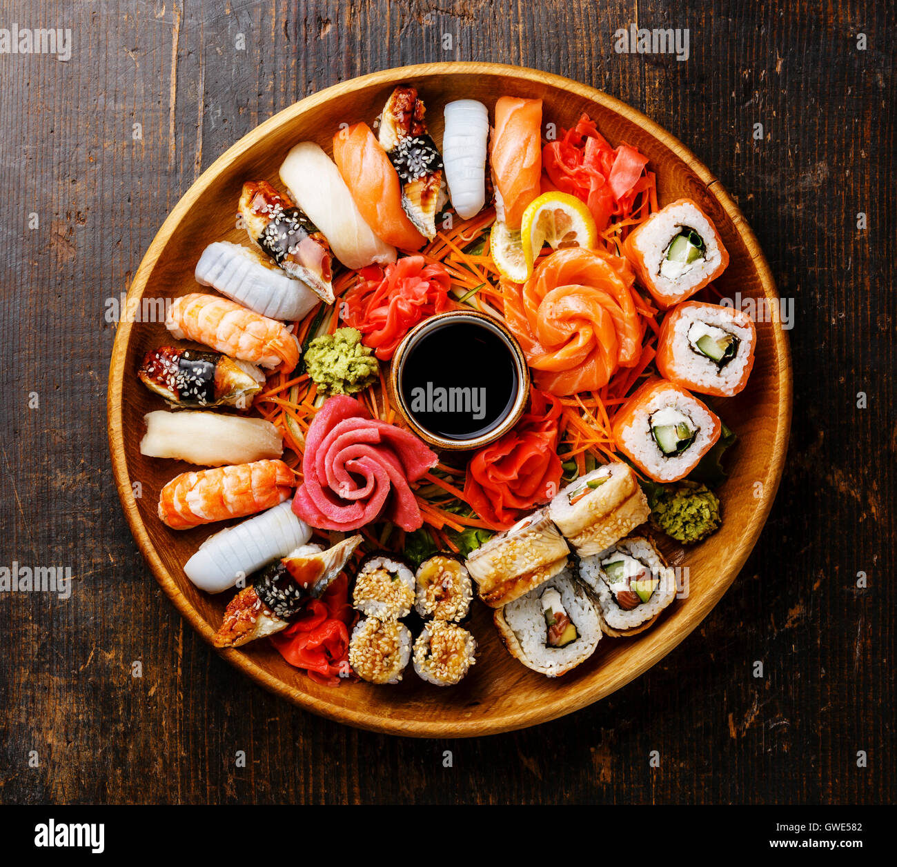 Set di sushi nigiri, rotoli e sashimi serviti in legno vassoio rotondo Foto Stock
