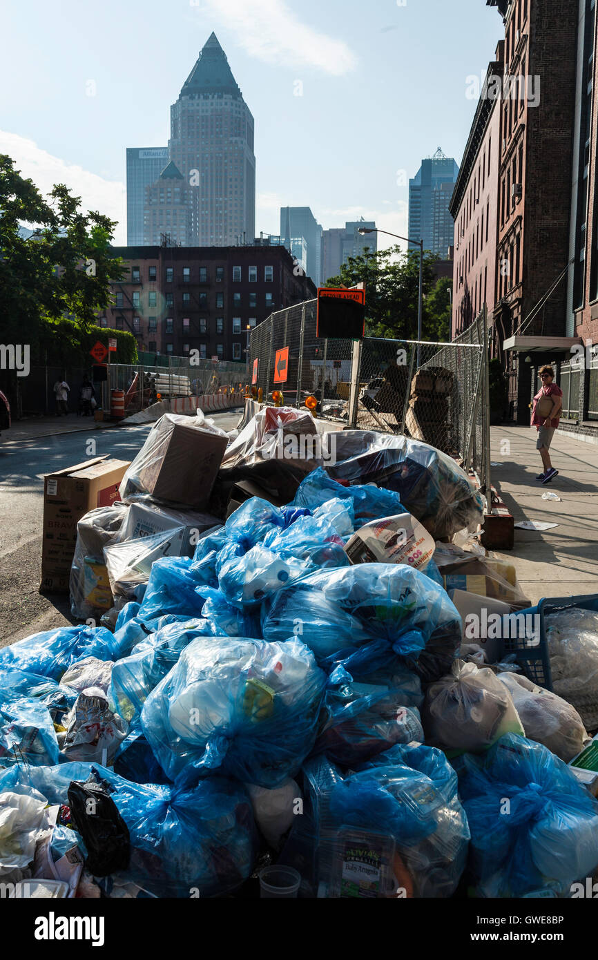 Cumuli di rifiuti in blu di sacchetti di plastica in attesa di raccolta dal lato della strada nella città di New York. Foto Stock