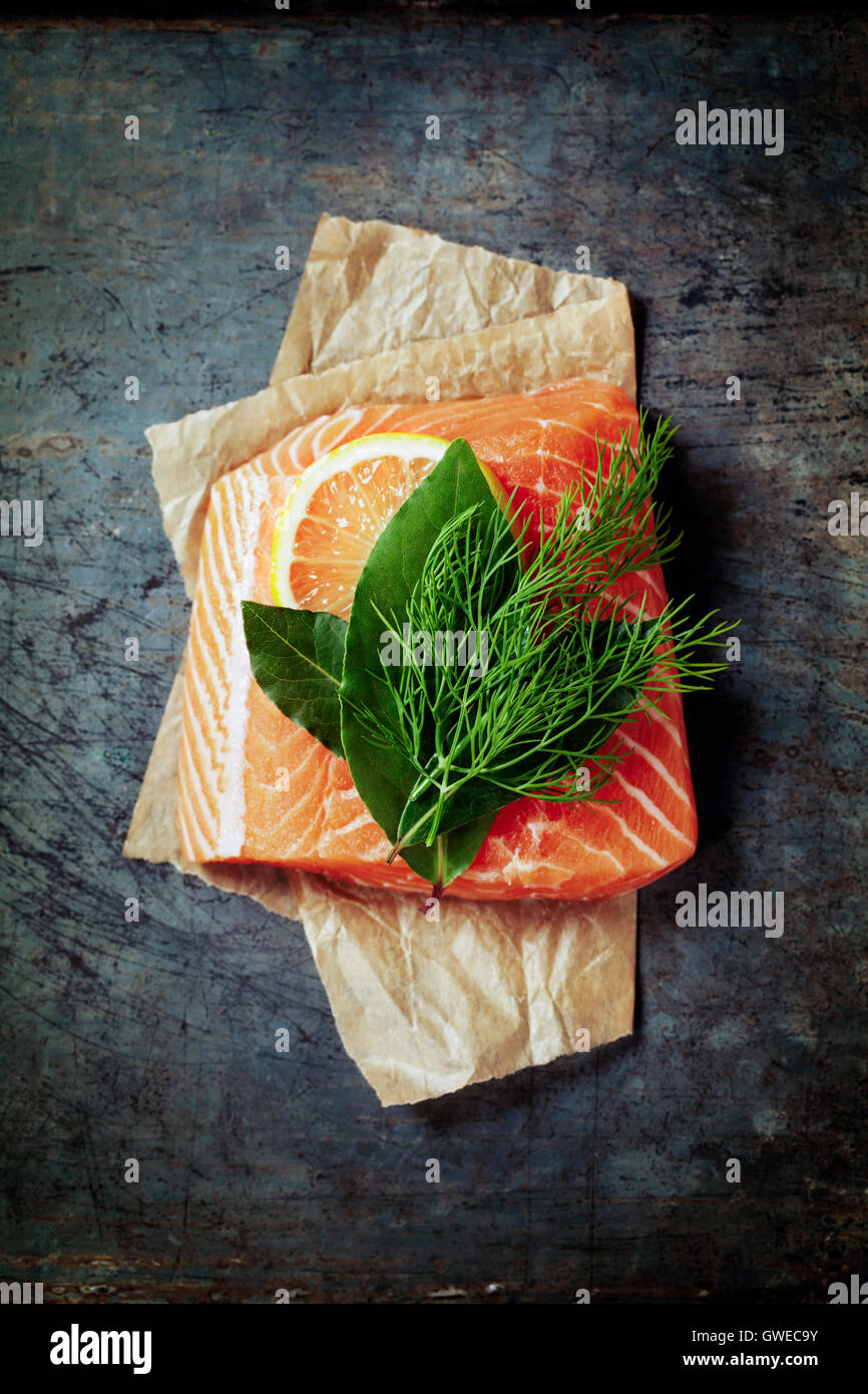 Materie filetto di salmone e gli ingredienti per cucinare in uno stile rustico. Vista superiore Foto Stock