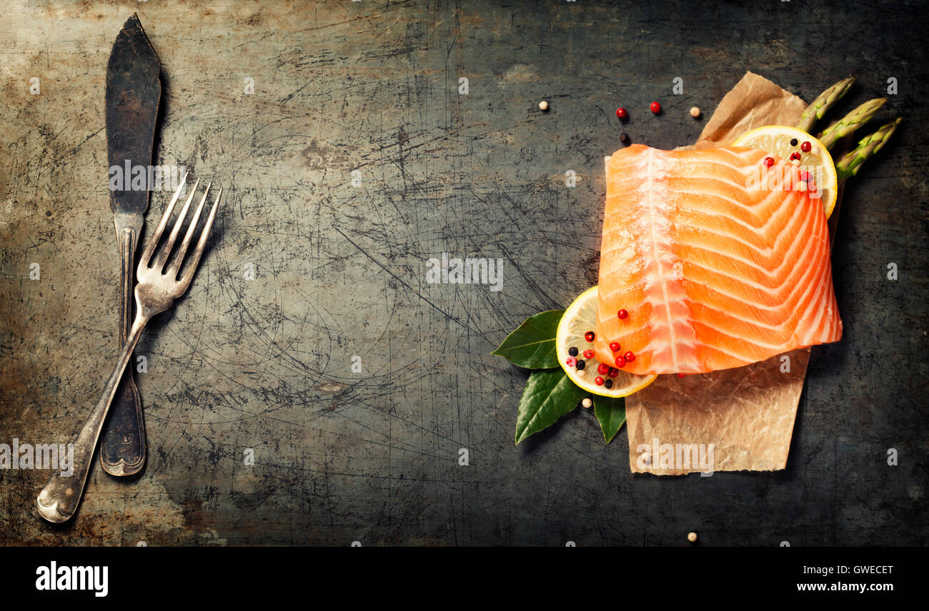 Materie filetto di salmone e gli ingredienti per cucinare in uno stile rustico. Vista superiore Foto Stock