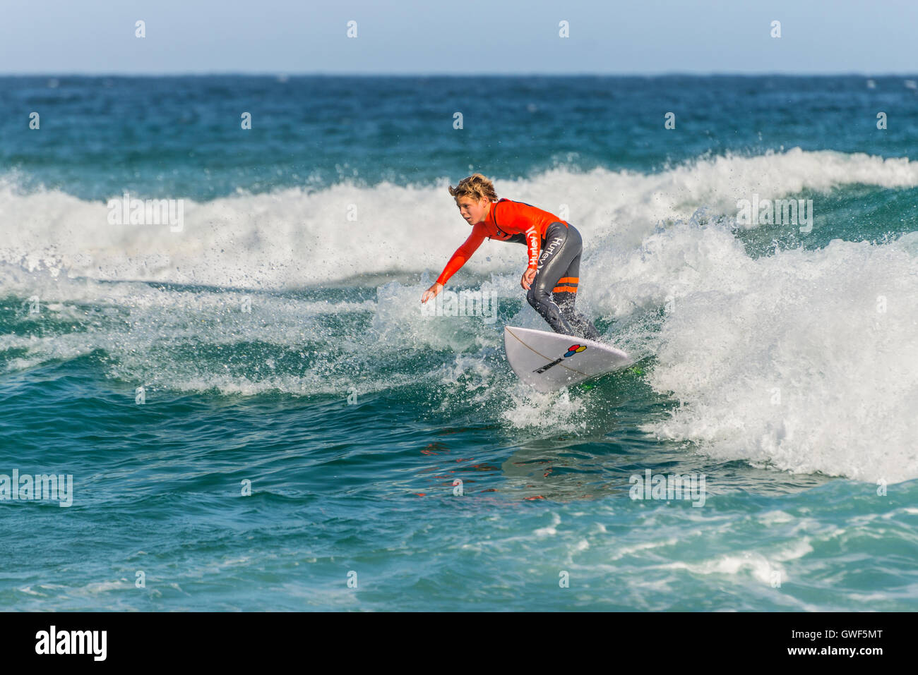 Un giovane australiano surfer sull'onda, la spiaggia di Bondi nella periferia est di Sydney Foto Stock