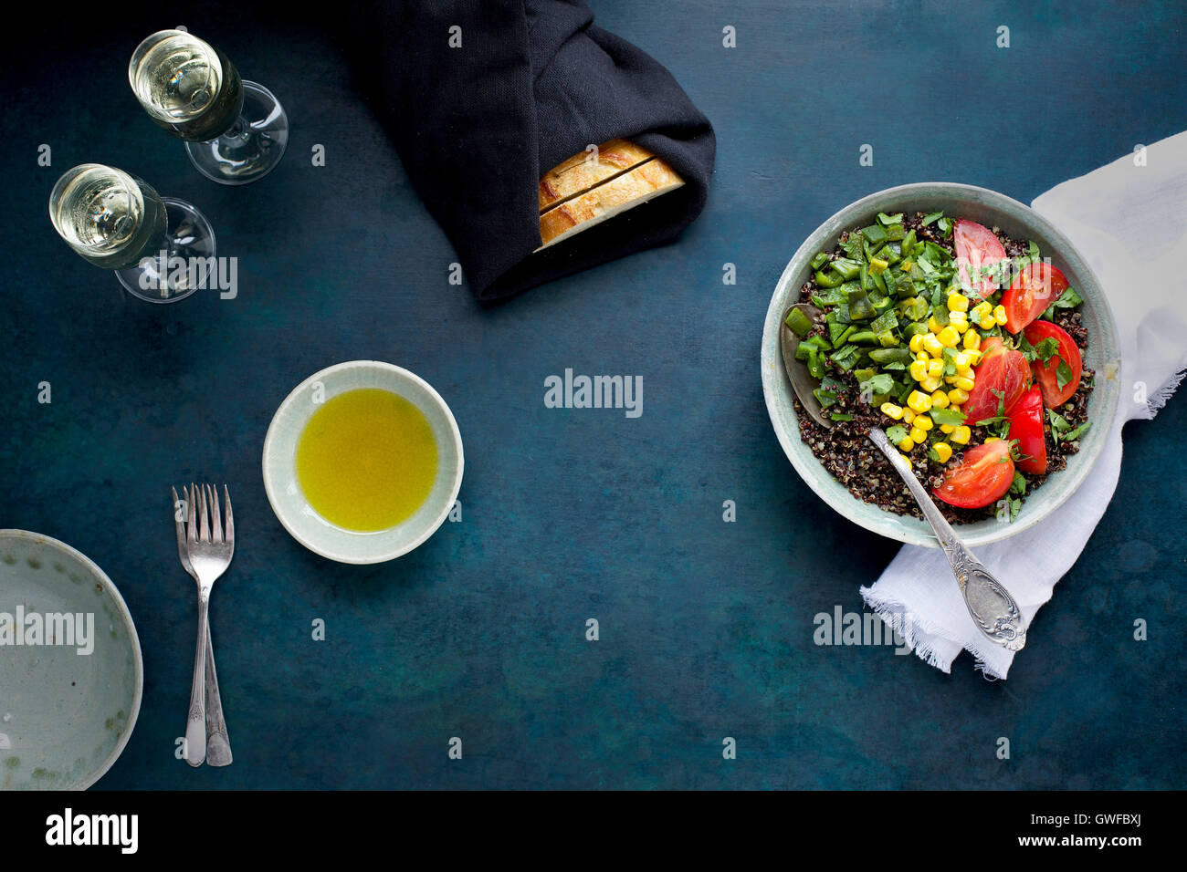 Poblano arrosto di Quinoa e rabboccato con mais, pomodori e coriandolo. Servita con vino bianco, olio d'oliva e pane. Fotografato da t Foto Stock