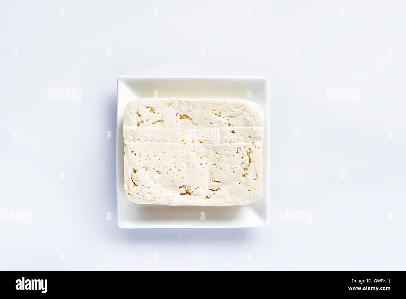 Il tofu su una piastra bianca su un tavolo bianco, fresco cibo vegetariano, sostituto della carne Foto Stock