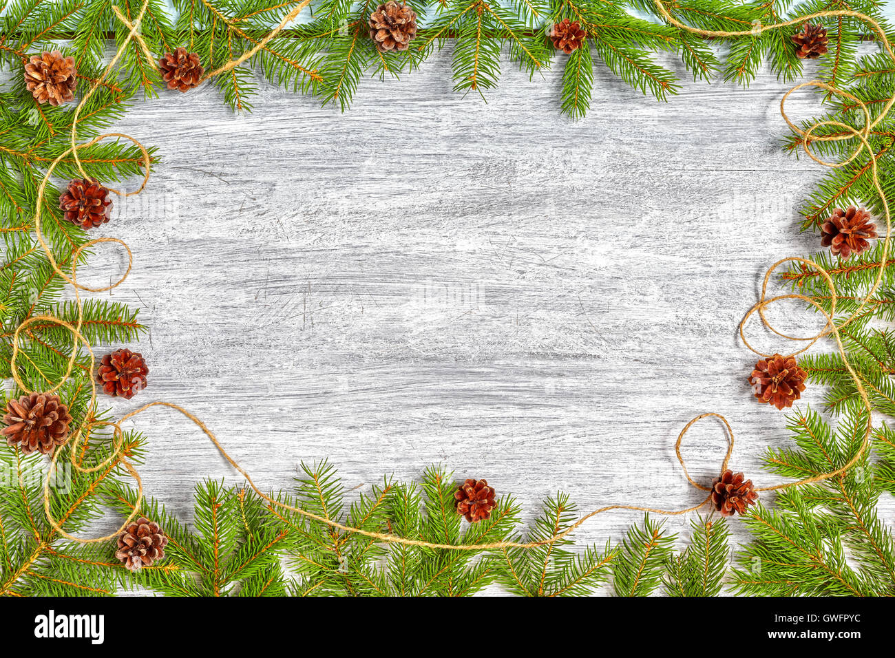 Sfondo di natale, Abete rami telaio con pigne su una tavola in legno rustico, vista dall'alto con copia spazio. Foto Stock