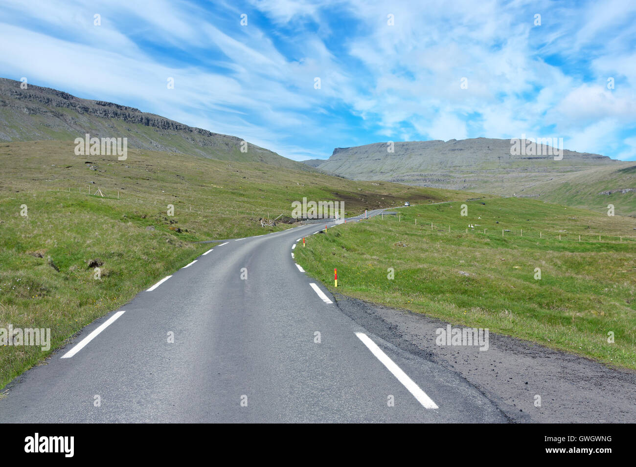 Strada che corre attraverso le verdi vallate delle isole Faerøer Foto Stock