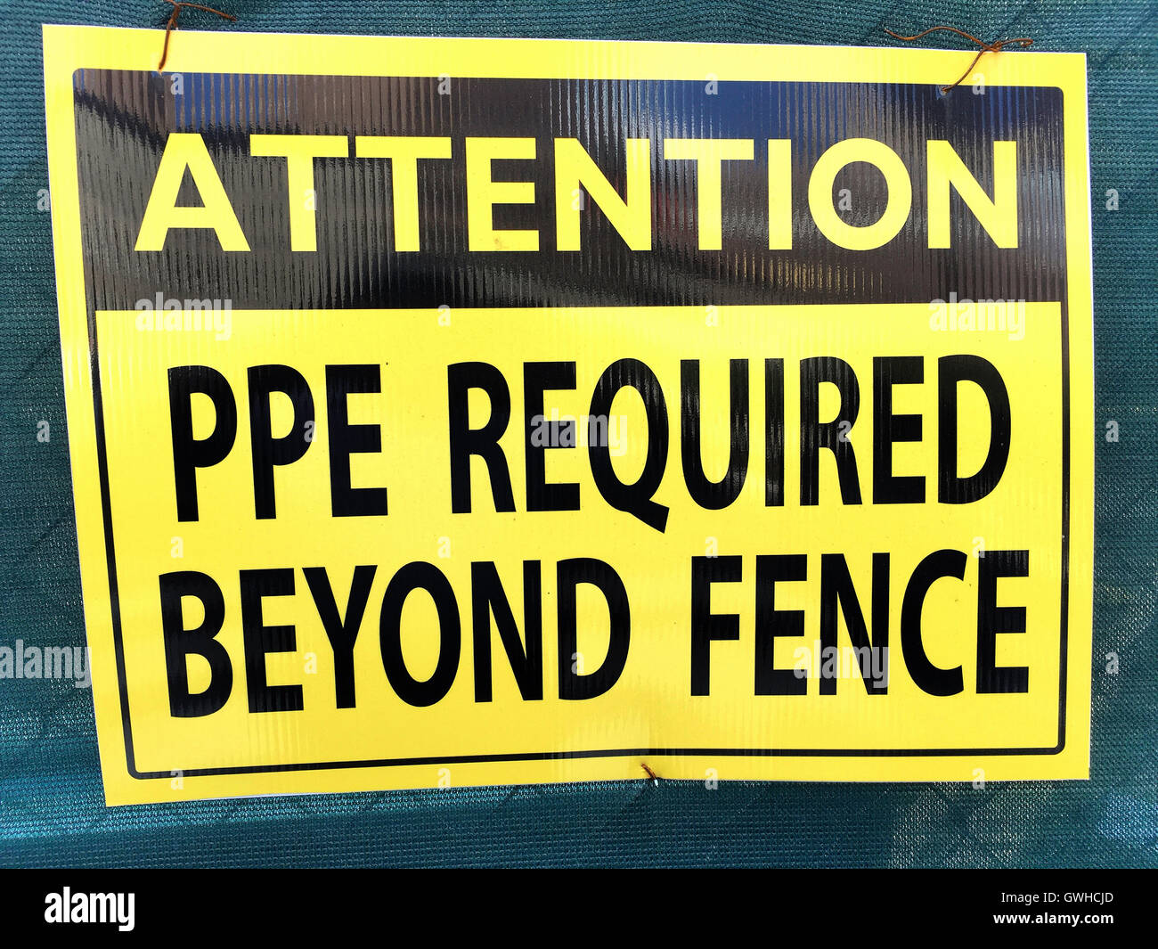 Attenzione "DPI richiesto oltre il recinto" Segno Foto Stock