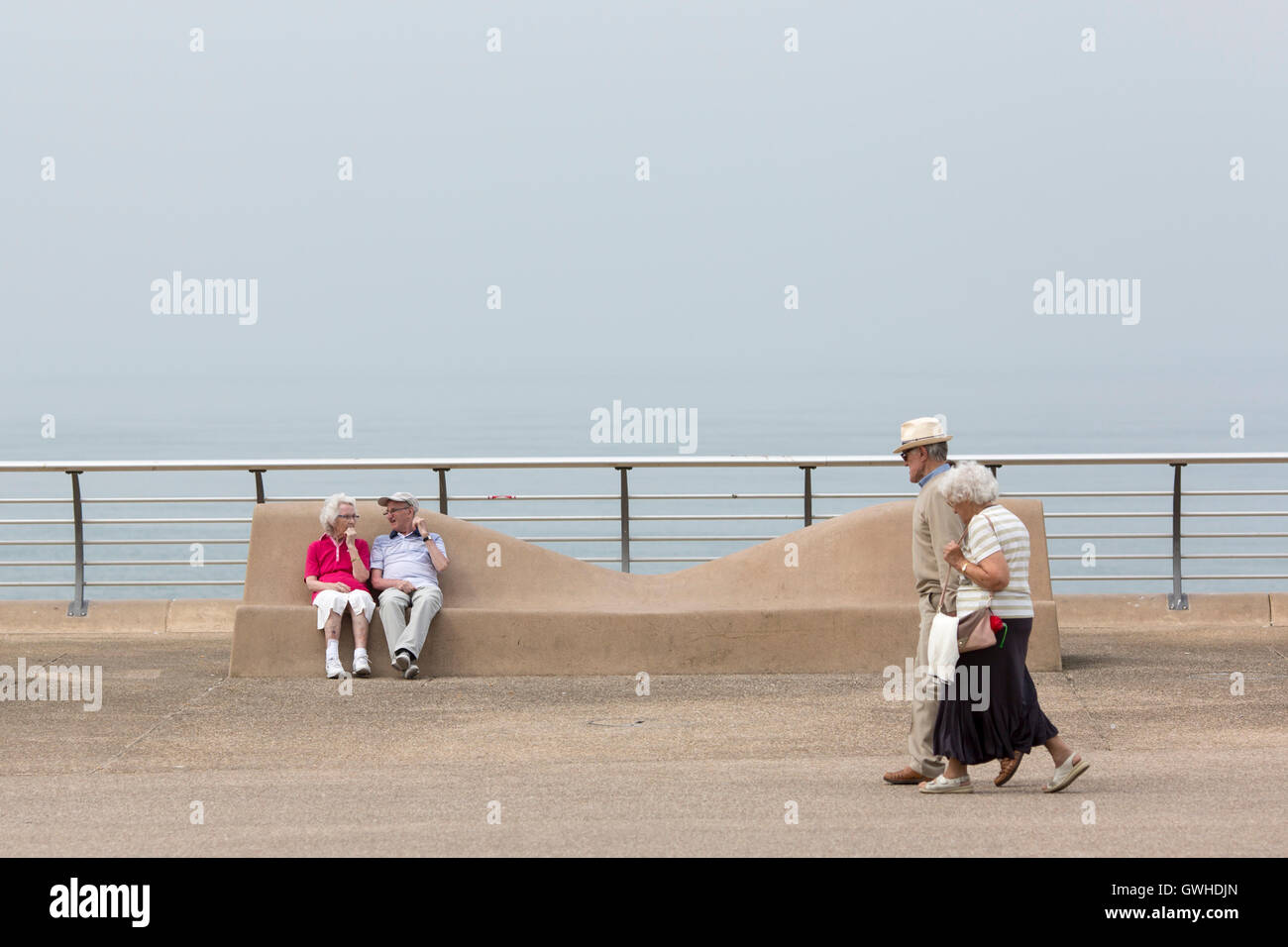 Due coppie di anziani godono di un clima caldo e sulla Promenade di Blackpool , Inghilterra Foto Stock