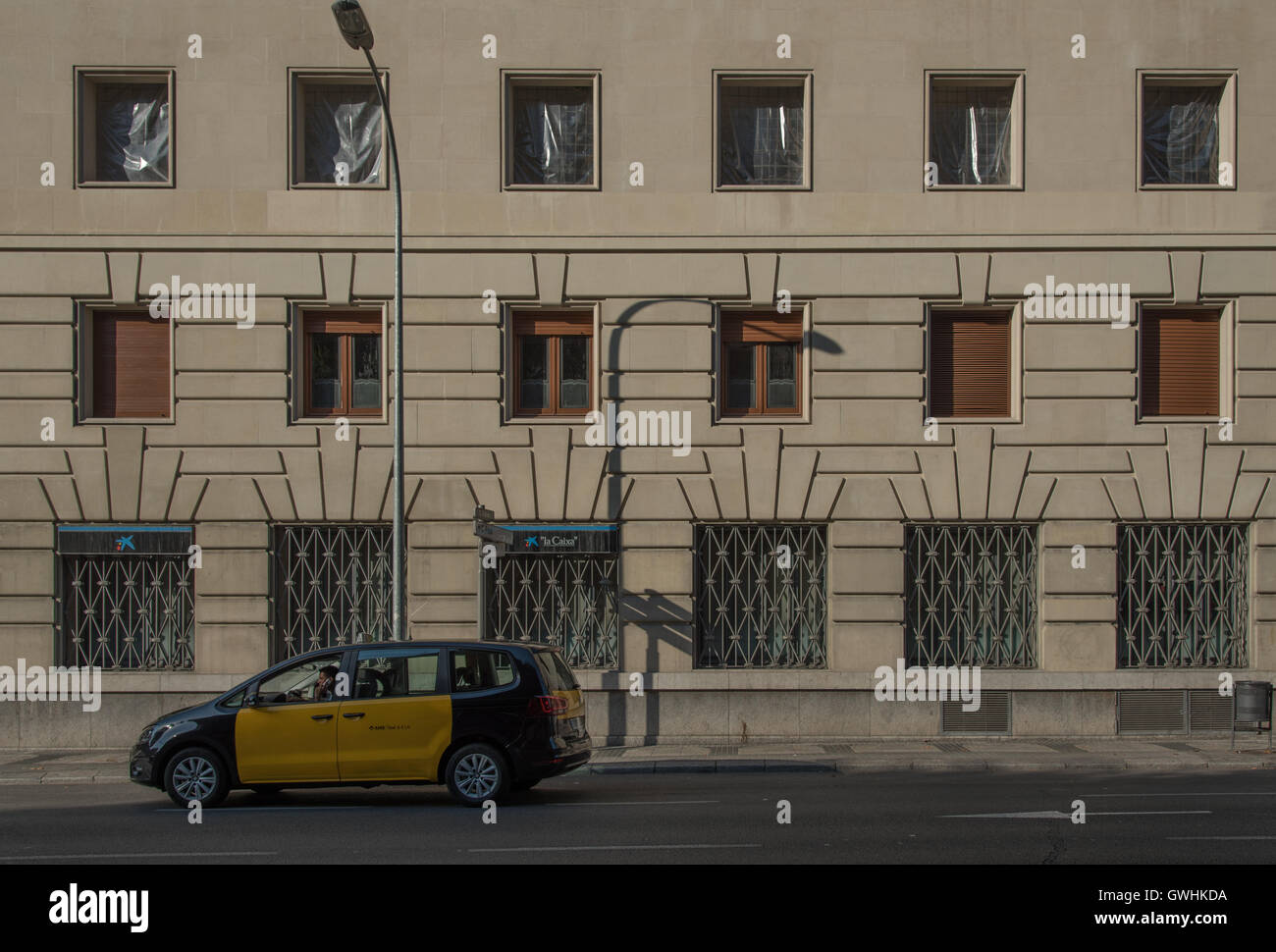 Una facciata a Barcellona con 18 finestre. Non lontano dalla metro Diagonal. Un nero e giallo taxi in primo piano. Foto Stock