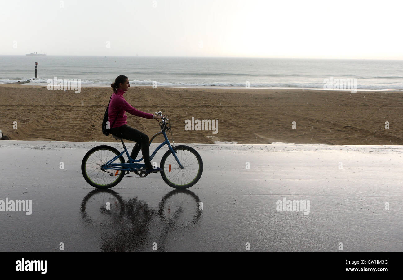 Un ciclista braves la pioggia come una tempesta di tuoni e fulmini passa al di sopra di Bournemouth Dorset, come il Regno Unito vede entrambi i temporali e il caldo sole estivo su quello che potrebbe essere il più caldo settembre giornata in più di cinquant'anni. Foto Stock