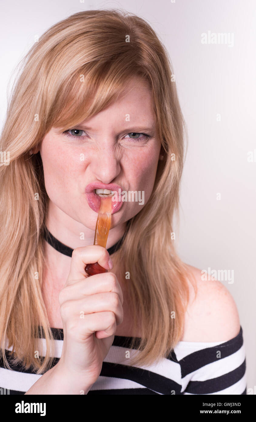 Bella donna bionda è il traino su un vino gum in bocca Foto Stock
