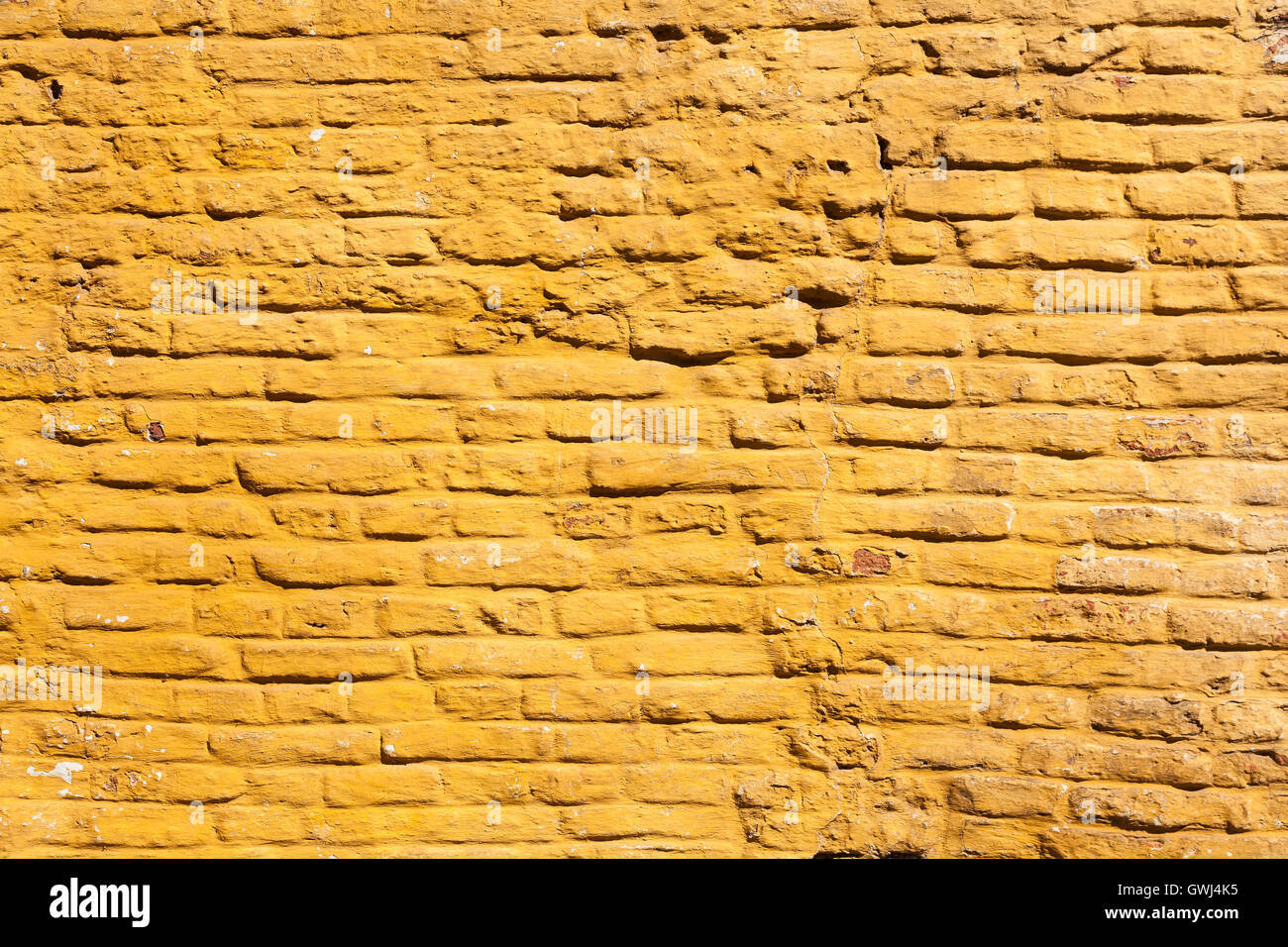 Parte quadrata di colore giallo ocra dipinte di un muro di mattoni Foto Stock