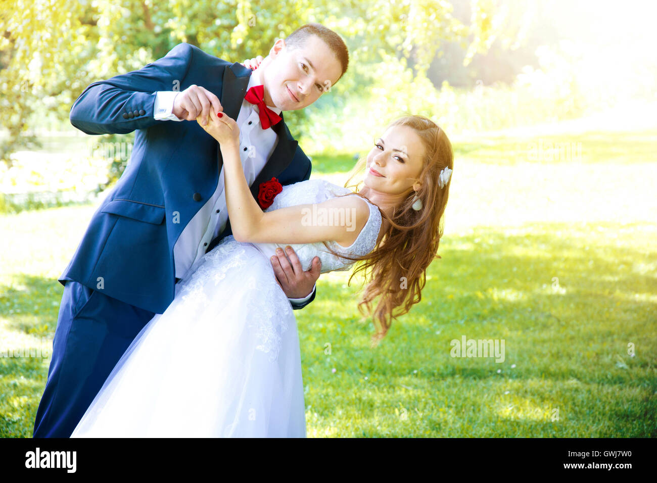 Coppie in viaggio di nozze danza nel parco verde in estate. Il matrimonio di nozze e concetto di immagine. Foto Stock