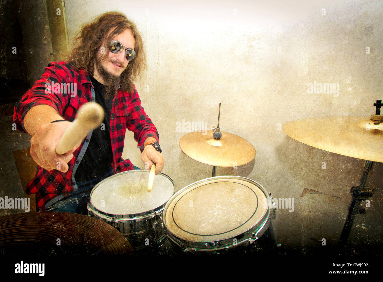 I tamburi immagine concettuale. Batterista Rock holding bacchette e giocando sui tamburi. Retro Vintage grunge immagine. Foto Stock