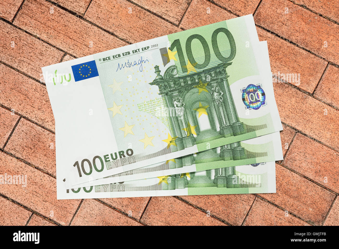 Un centinaio di banconote in euro su Sfondo mattone Foto Stock