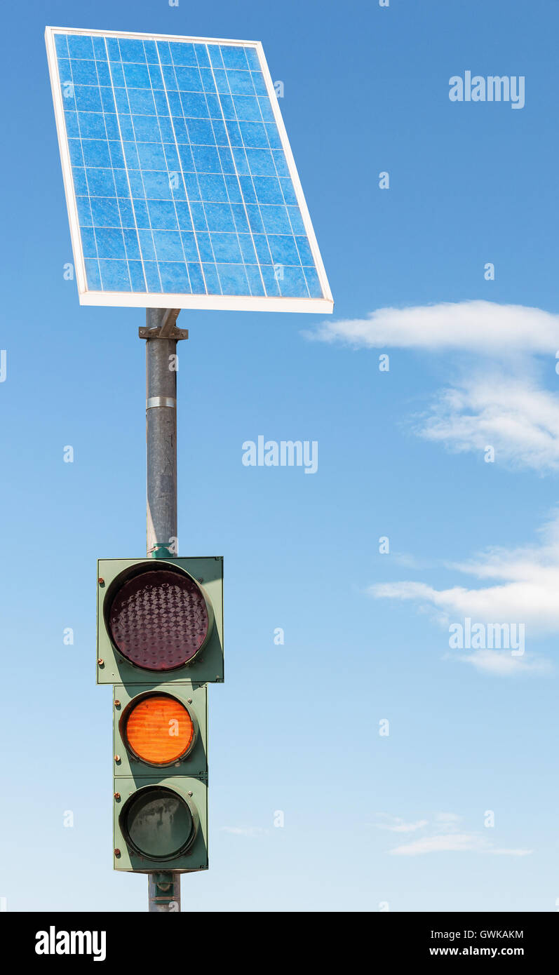 Il traffico su strada luce alimentato da energia elettrica generata da un pannello solare. Cielo blu Foto Stock