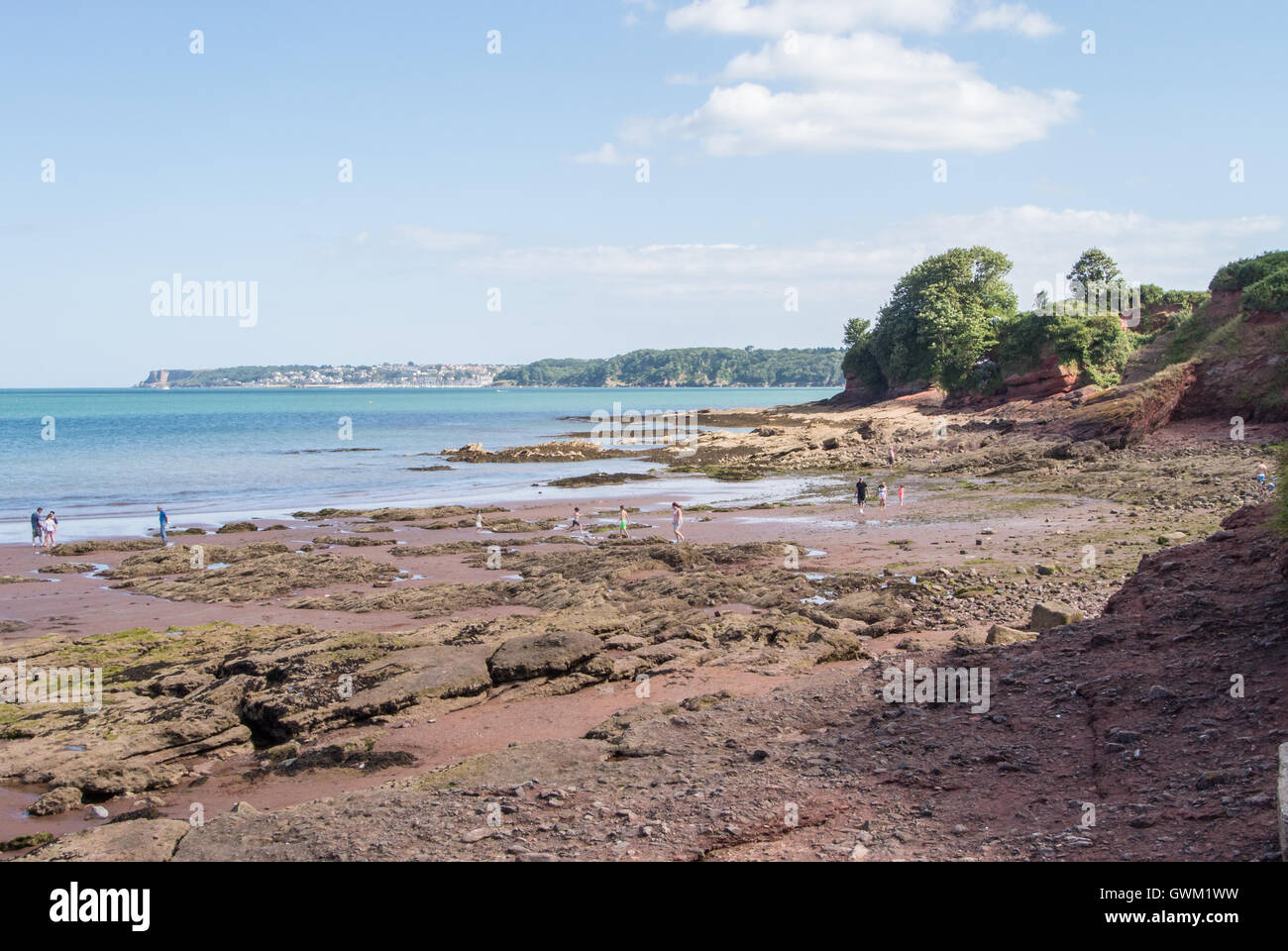 Le piscine di roccia a Goodrington Sands Beach con Brixham in distanza Foto Stock