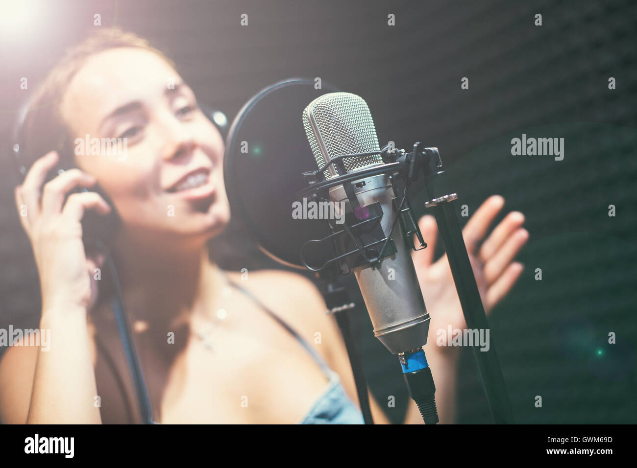 Ragazza a cantare in un microfono in studio Foto Stock