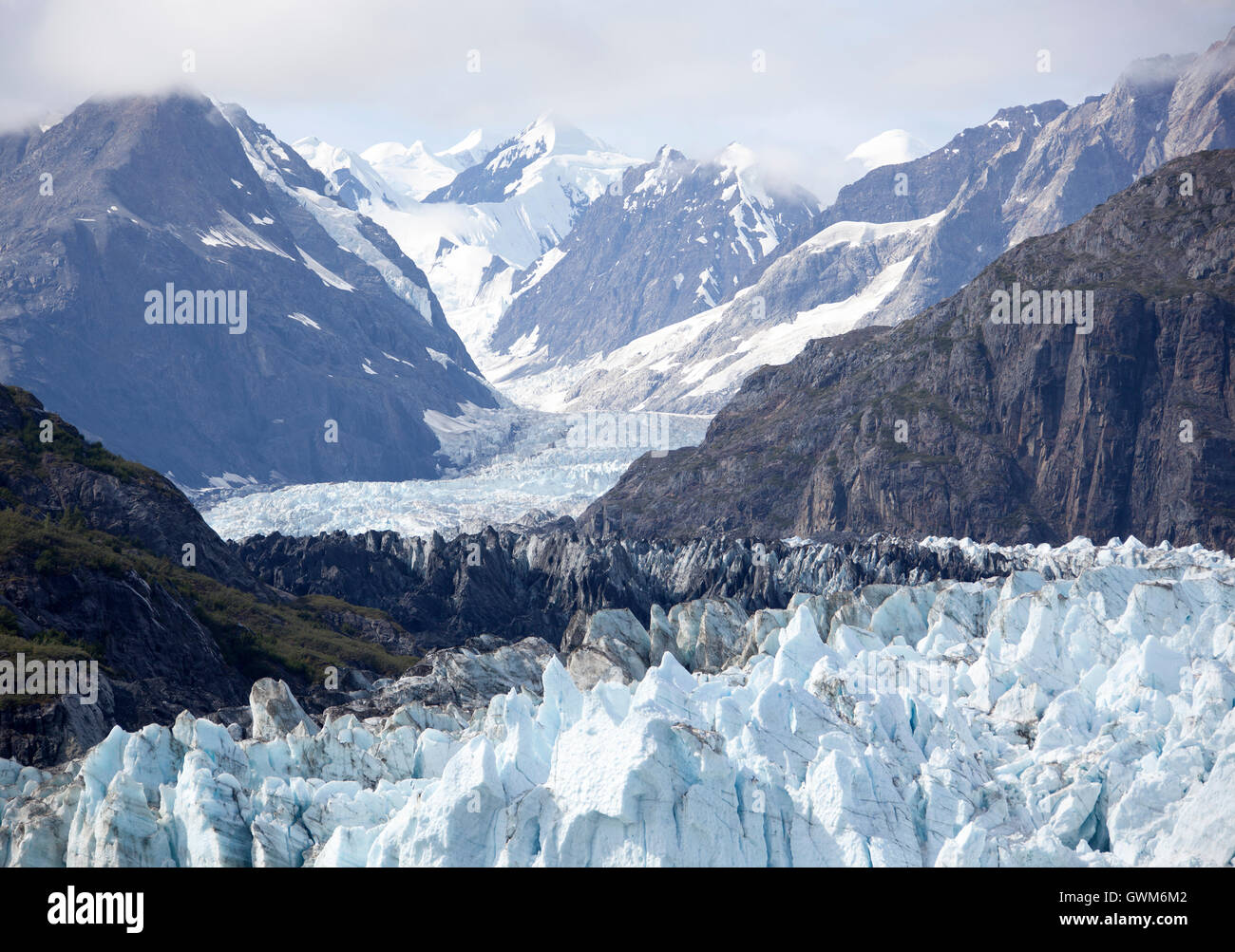 La vista del ghiacciaio curvo per stiramento lontano montagne del parco nazionale di Glacier Bay. Foto Stock
