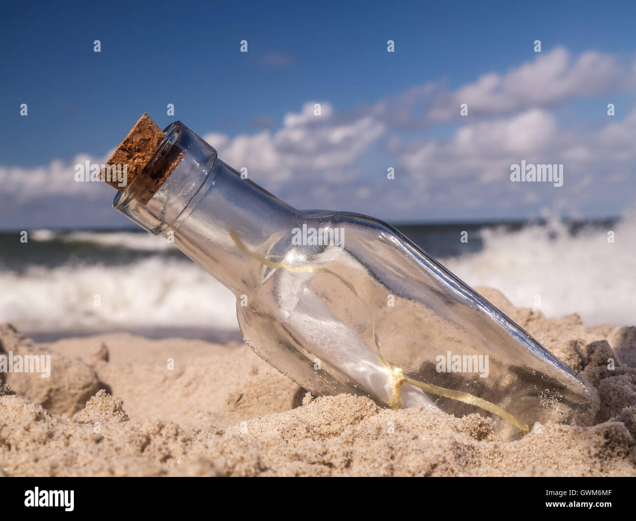Bottiglia tappato con messaggio bloccato nella sabbia sulla spiaggia Foto Stock