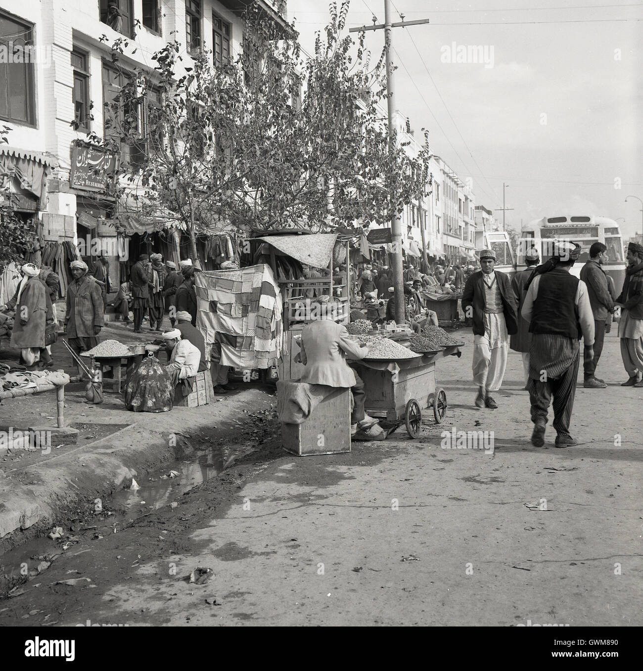 Degli anni Cinquanta, foto storiche di una strada a Kabul, Afghanistan, mostra mercato afgano commercianti sul marciapiede. Foto Stock