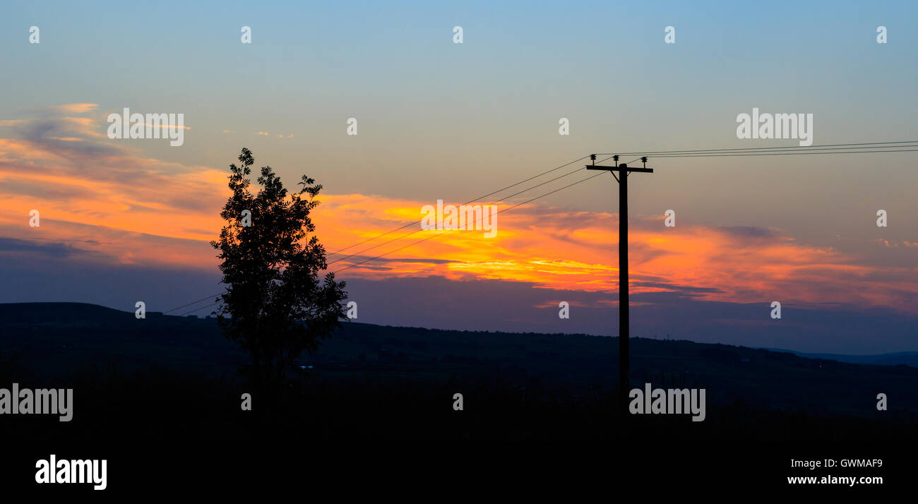 Linea di alimentazione silhouette al tramonto nello Yorkshire, Regno Unito. Foto Stock