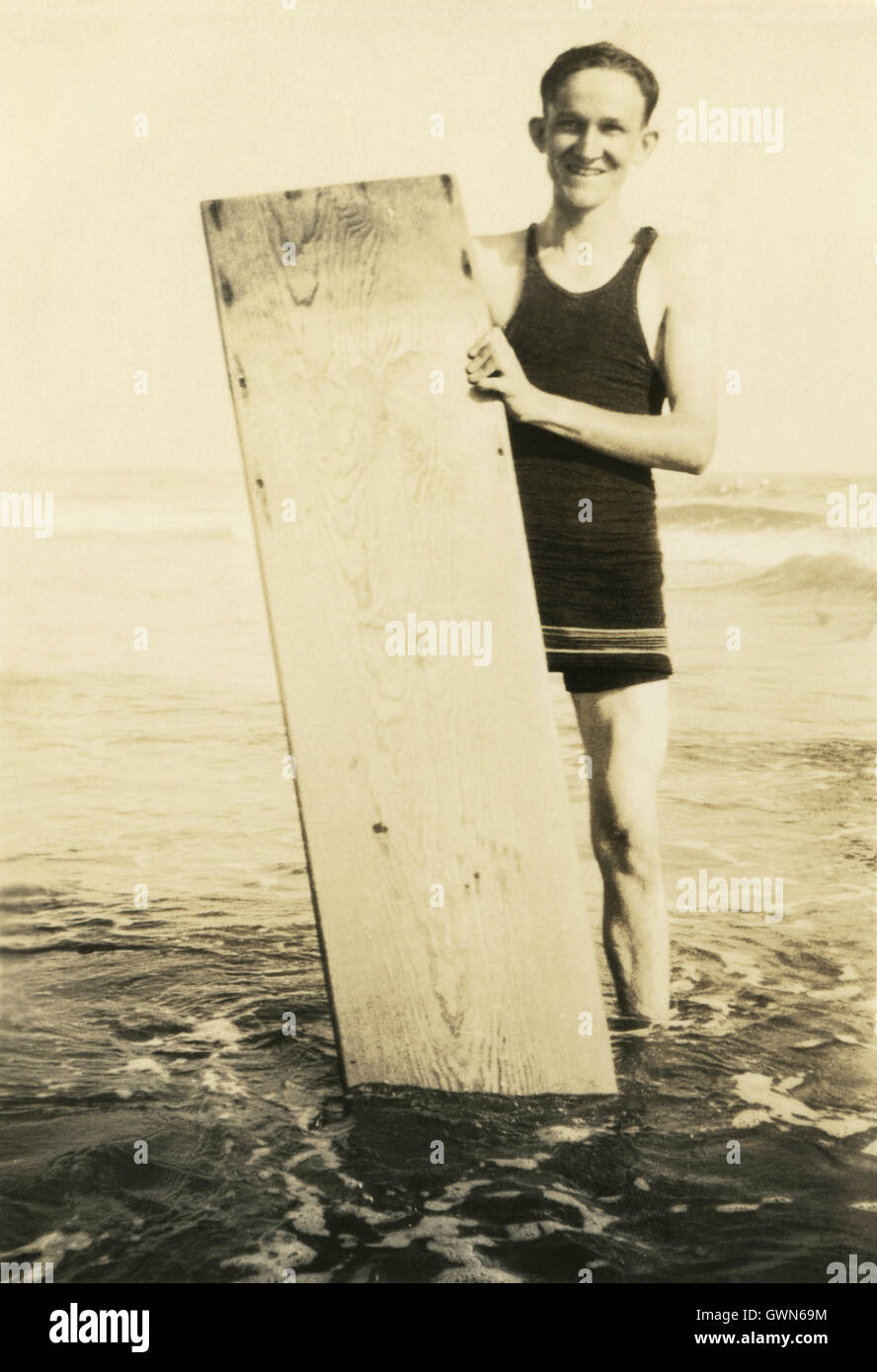 Inizio del ventesimo secolo foto di un uomo con la tavola da surf in legno. Foto Stock