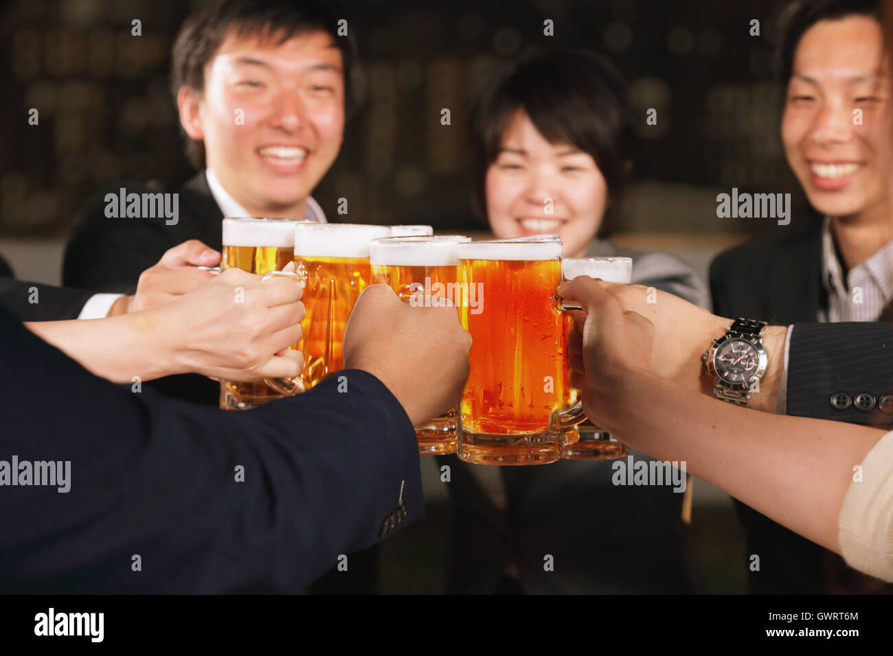 Un gruppo di giovani amici giapponesi la tostatura con birra Foto Stock