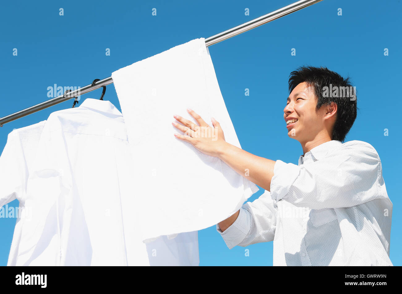 Un giovane giapponese uomo che fa servizio lavanderia Foto Stock
