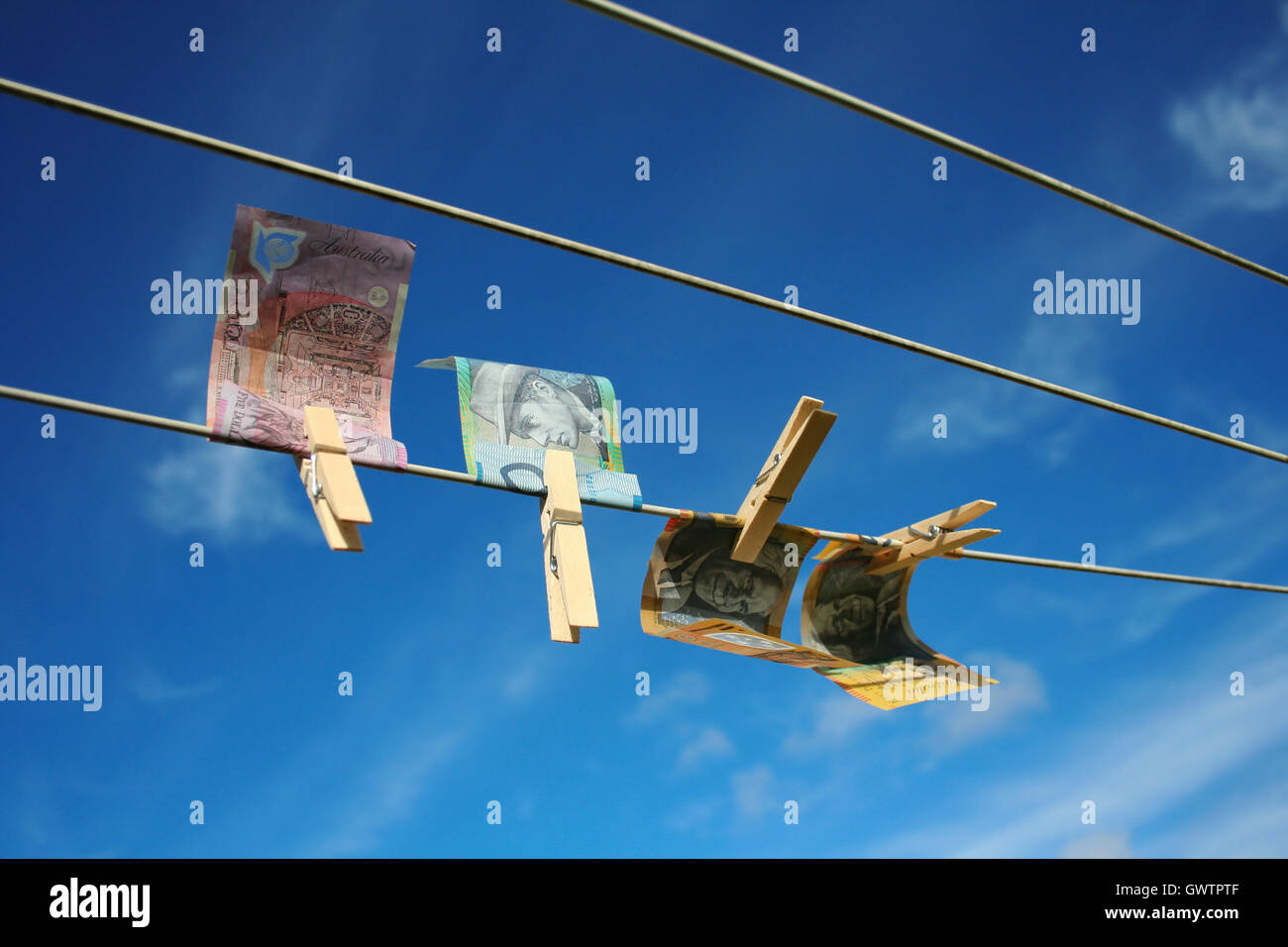 Note australiano ancorato sulla linea di lavaggio isolata contro il cielo blu. Riciclaggio di denaro del concetto. Foto Stock