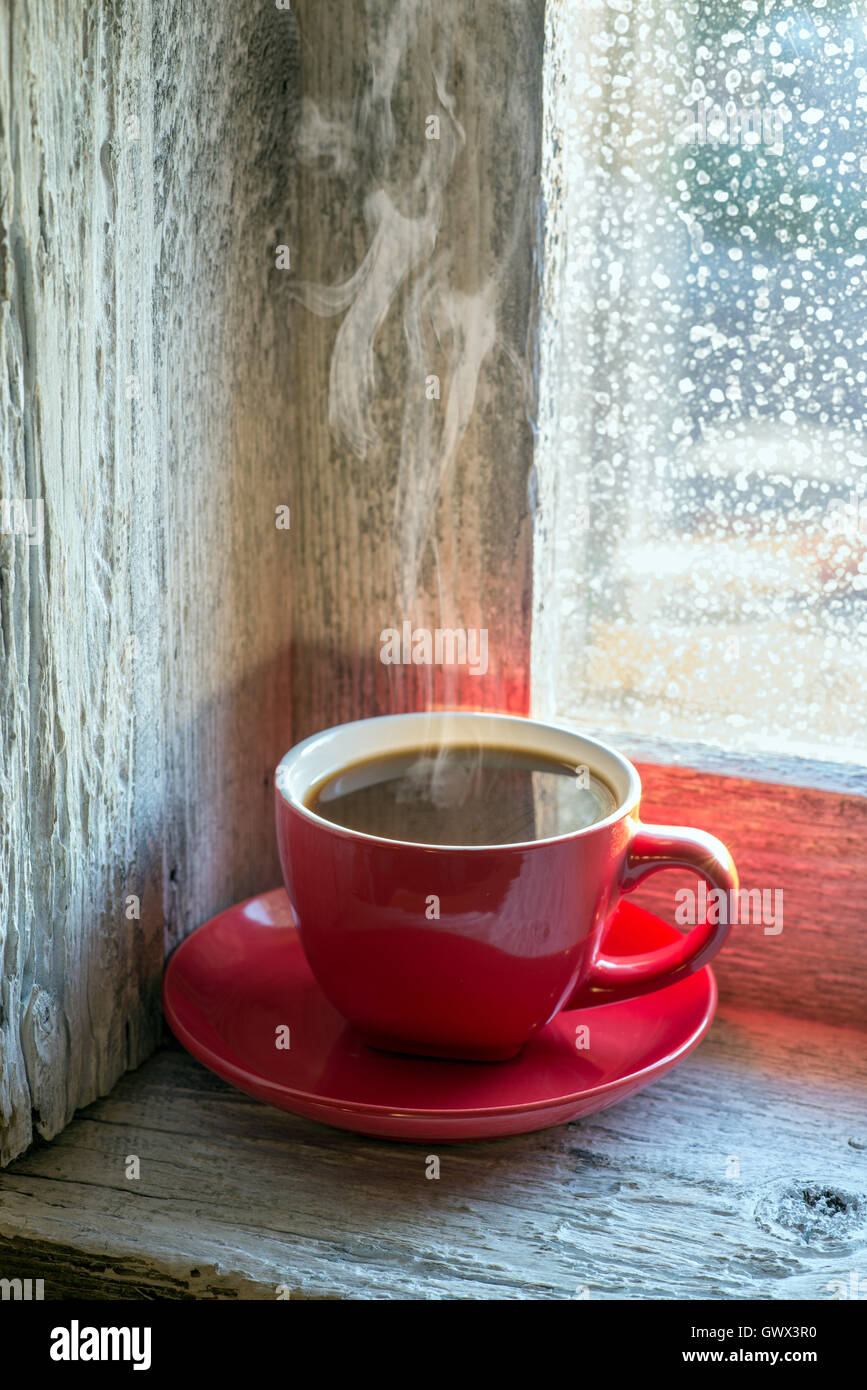 Tazza di caffè fumante su un davanzale Foto stock - Alamy