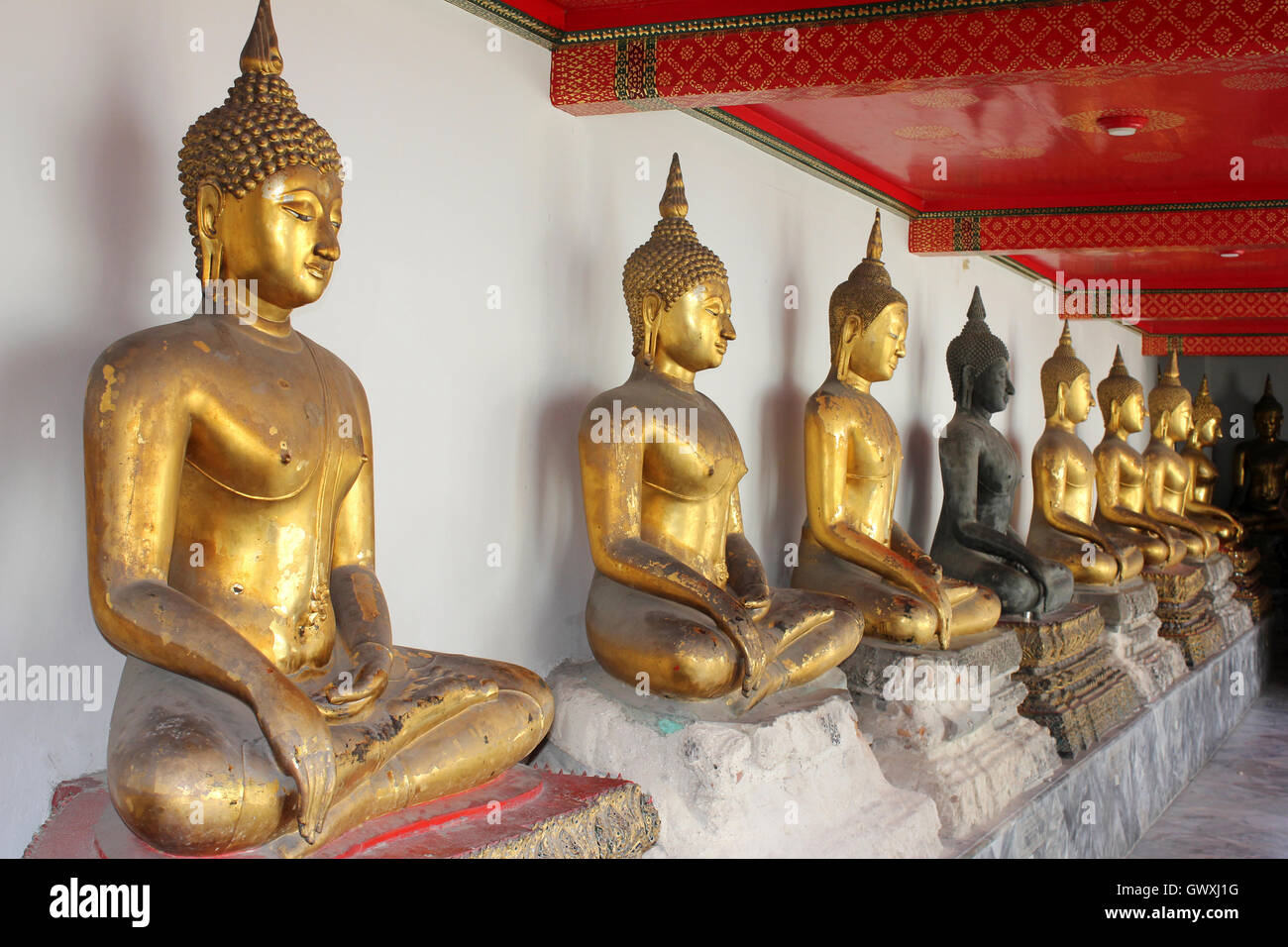 Linea di Buddha seduto al Wat Pho tempio di Bangkok, Tailandia Foto Stock