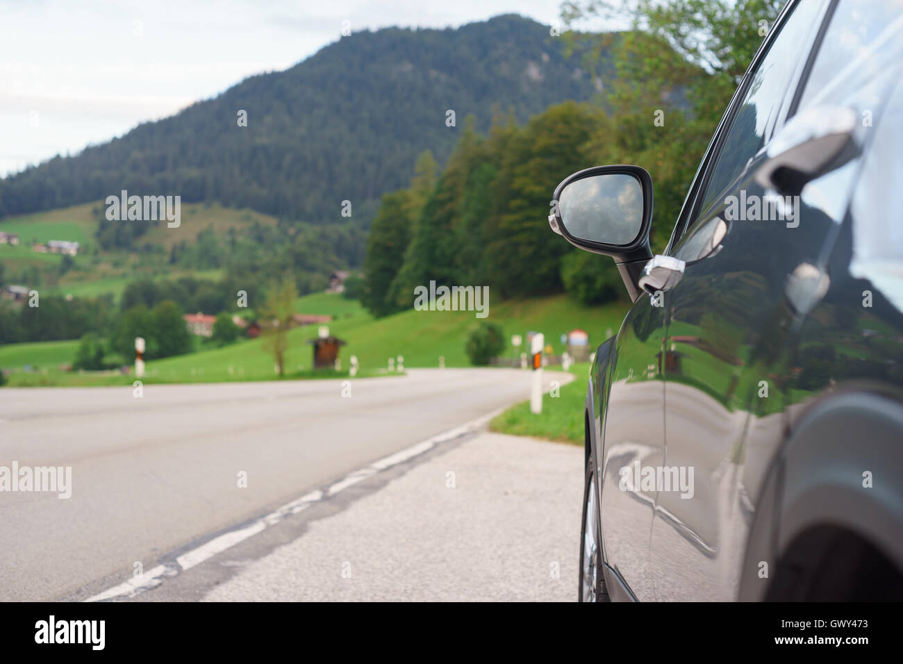 Auto parcheggiate sul ciglio della strada di fronte a monte e valle alpina. Concetto di viaggio Foto Stock
