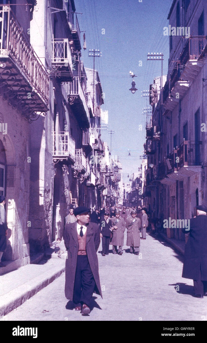1951, storico, post-guerra mondiale 11 e il personale militare vagare attraverso un antica strada nella città di Gela, Sicilia, Italia. Foto Stock