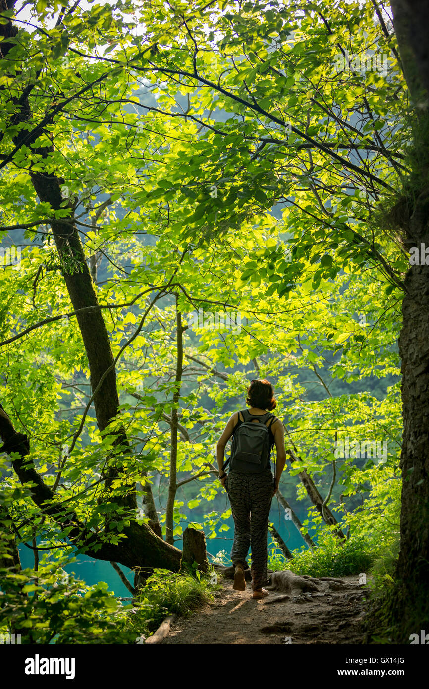 Una donna di passeggiare lungo il fiume Korana, che crea il mondo-famoso parco dei laghi di Plitvice, un sito Patrimonio Mondiale dell'UNESCO (Croazia). Foto Stock