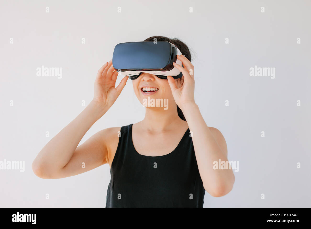 Colpo di felice giovane donna in VR auricolare guardando lontano gli oggetti in realtà virtuale. Femmina con la realtà virtuale ancora gli occhiali di protezione Foto Stock