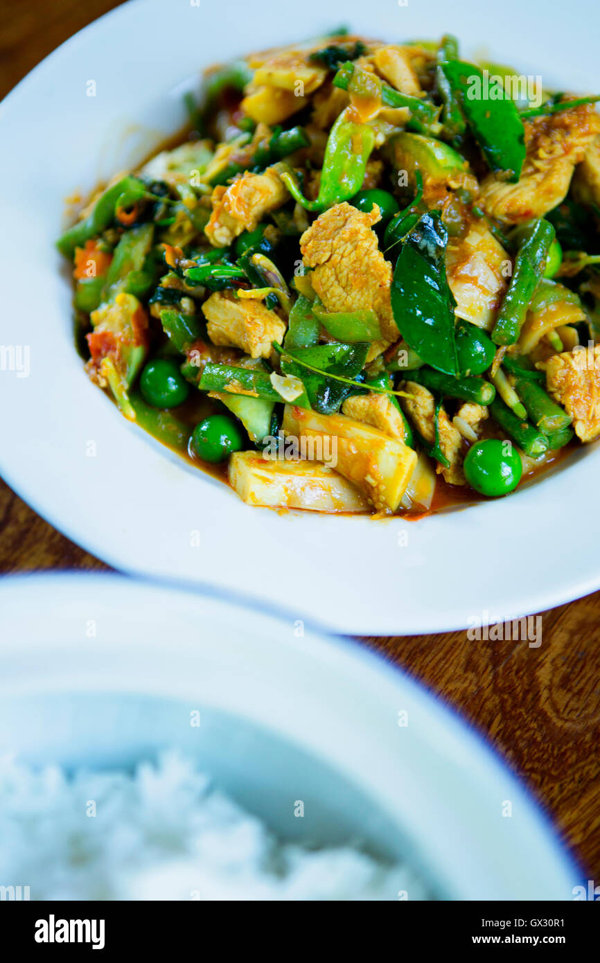 Thai stir fry con pollo, fagioli, piselli, basilico fresco e foglie di combava Foto Stock