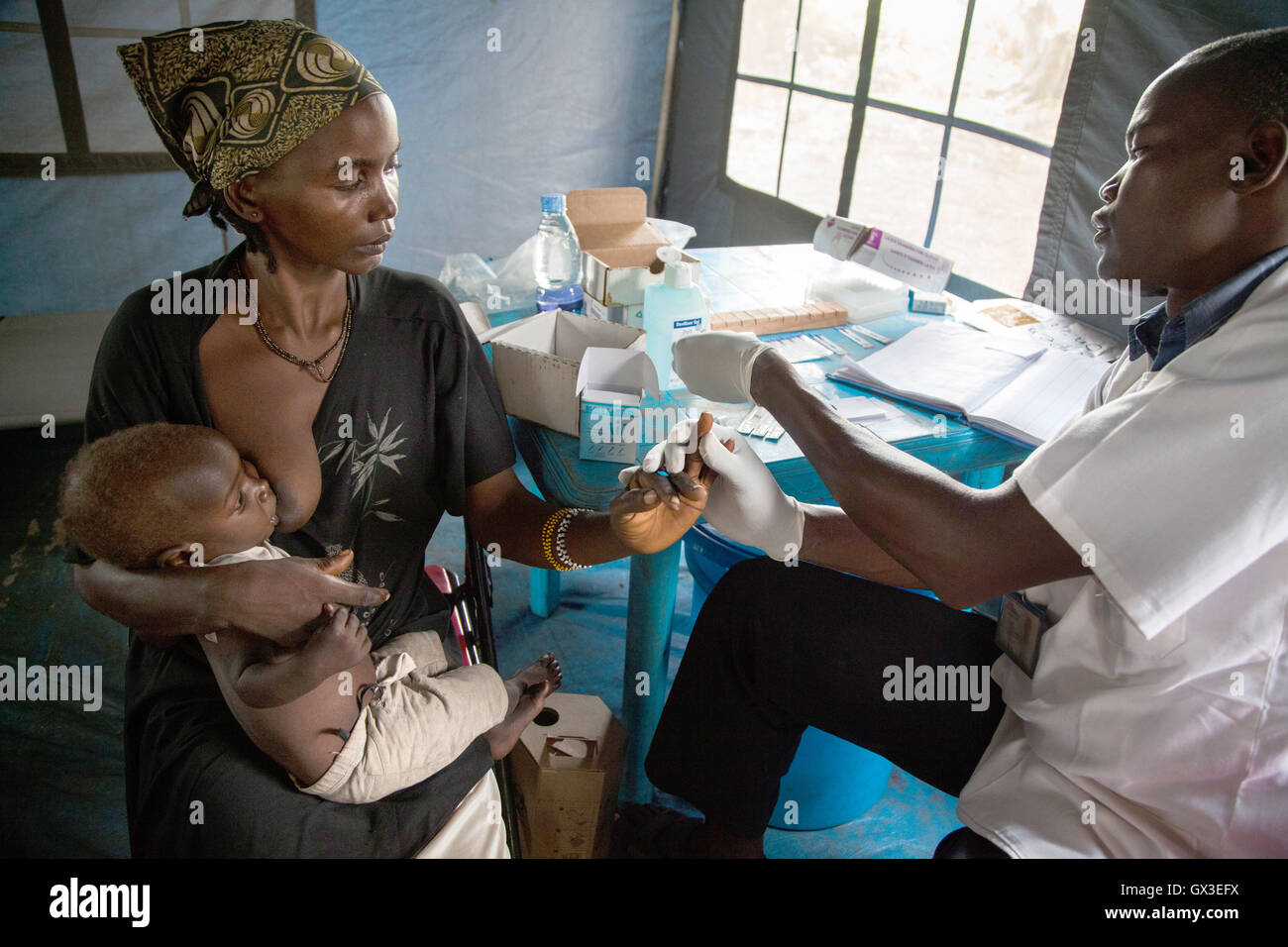 Nambiri, Sud Sudan. 19 giugno 2016. Joyce Simon tiene il suo bambino come lei prende un test HIV in clinica mobile dell organizzazione umanitaria internazionale "Medici Senza Frontiere (MSF) in Nambiri, sud Sudan, 19 giugno 2016. Foto: Anna Kerber/dpa/Alamy Live News Foto Stock
