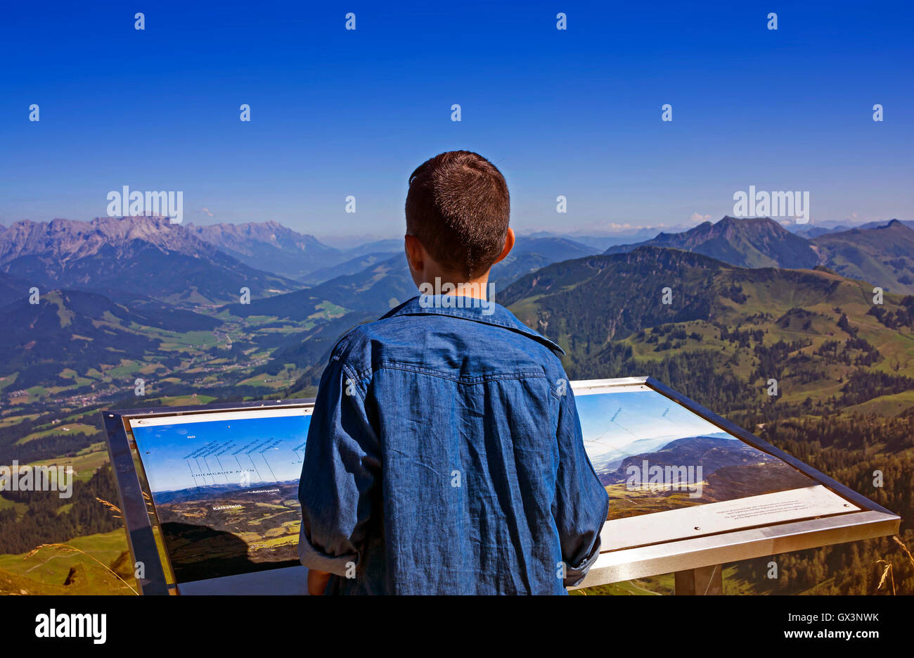 Giovane ragazzo ad esplorare le Alpi in Tirol, Austria, dal picco di Kitzbuhel Foto Stock